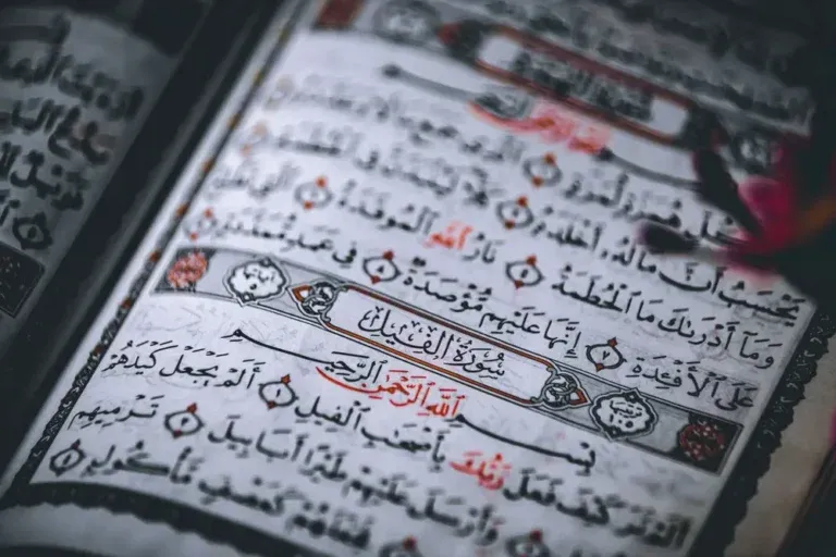 Open Quran with Tajweed rules, prayer beads and reed pen — beginner's guide to learning Tajweed step by step
