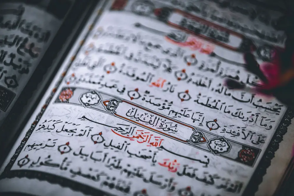 Open Quran with Tajweed rules, prayer beads and reed pen — beginner's guide to learning Tajweed step by step